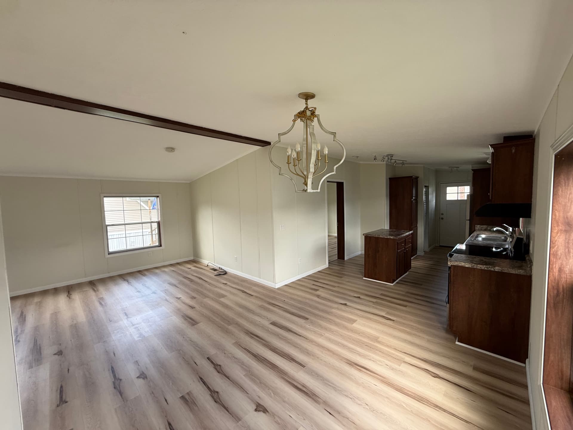 Open living and dining area at 15 Kevin with chandelier and wood-look flooring